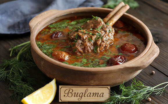 National cuisine of Azerbaijan A photograph showcasing a rustic clay pot filled with Buglama, a traditional Azerbaijani lamb stew. The stew itself features tender chunks of lamb submerged in a rich, r