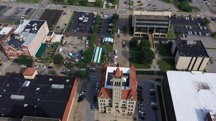 Enjoy a sweeping aerial view of downtown Parkersburg, West Virginia, highlighting a vibrant event, historic buildings, and the beautiful surrounding landscape.