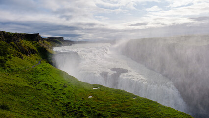 Majestic Gullfoss waterfall cascading amid Icelands breathtaking landscape during a cloudy day
