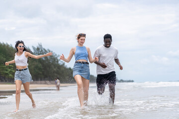 multiracial friends having fun on the beach,enjoy running in seashore together,smiling,laughing,people lifestyle,travel on summer vacations