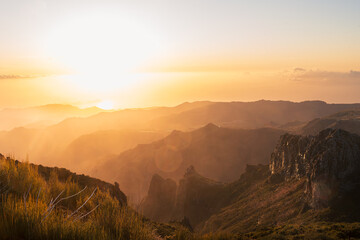 Levée de soleil doré sur un paysage montagneux avec brume et lumière chaude