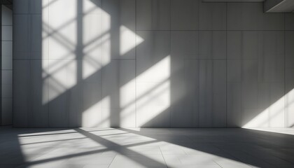 Obraz premium Sunlight streams through a patterned window, casting geometric shadows on a concrete wall and floor in an empty room.