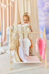Little child girl choosing her clothes.