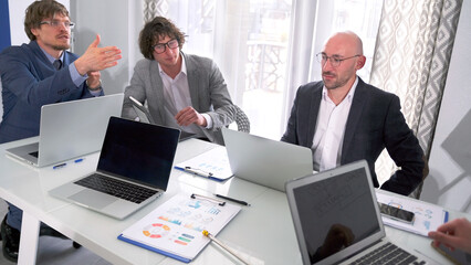The briefing. Several heads of large departments of the company are in a meeting. A group of men...