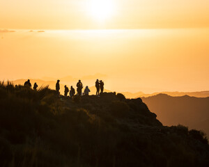 Groupe de randonneurs admirant le lever du soleil depuis un sommet
