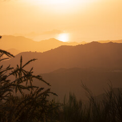 Obraz premium Coucher de soleil doré sur les collines et l'océan, vue paisible et naturelle