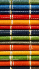 Stacked colorful textiles with visible stitching and texture