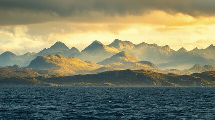 Golden light bathes mountain range above tranquil ocean.