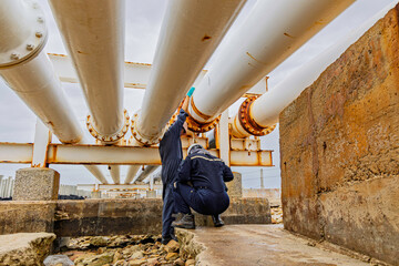 Male worker inspection and measurement thickness of rusted steel pipe, steel deterioration,...