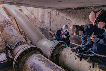 Male worker inspection of rusted steel pipe, underground steel deterioration, widespread corrosion, and confined spaces