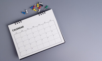 Appointment or reminder calendar with multicolored pins on gray background, schedule organization....