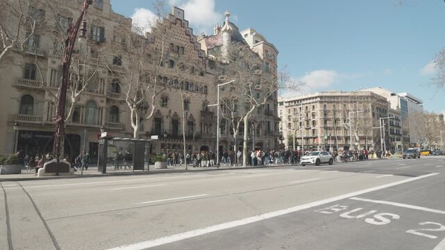 A vibrant urban street scene showcasing historic buildings and lined with trees. The lively atmosphere captures the essence of city life, inviting exploration and discovery among the architectural bea