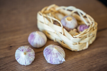 Basket with Chinese single clove garlic on kitchen countertop. Natural cooking ingredient, organic vegetable, and culinary preparation.