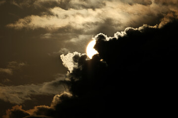 Sunlight Through Storm Clouds, Sun in the sky with dark clouds, Dramatic Sky with Emerging Sunlight