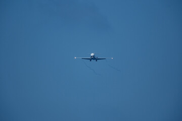 The plane approaching the airport. The plane is preparing to land. Airplane in the blue sky.