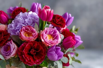 Vibrant floral bouquet with red carnations, purple tulips, and pink peonies
