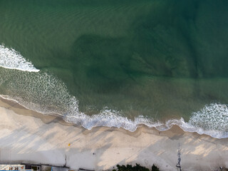 top view of turquoise blue beach with waves forming