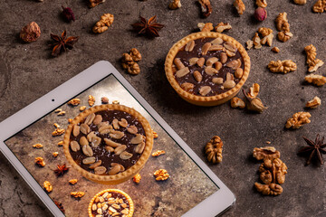 Delicious composition with two chocolate tarts and a tablet