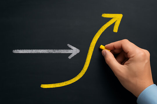 Business growth and transformation concept with hand drawing yellow curved arrow overtaking straight gray line on chalkboard to symbolize upward change