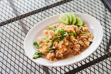 A delicious-looking plate of fried rice is placed on a grid table, giving it a casual feel.