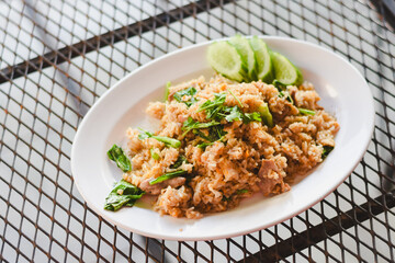 A delicious-looking plate of fried rice is placed on a grid table, giving it a casual feel.