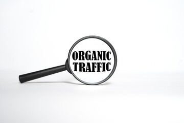 ORGANIC TRAFFIC said in a magnifying glass. bright white background.