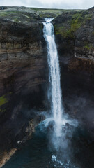 Stunning Haifoss waterfall cascading into a serene pool in Icelands dramatic landscape