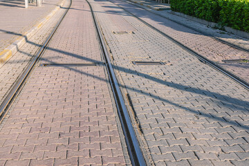 Tram tracks with tiles laid between the rails. Urban transport and roads for trams. View of the road and rails. Tram tracks.