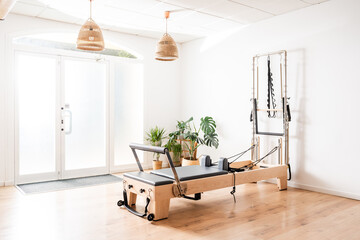 Pilates reformer and Cadillac equipment standing in a modern and bright studio