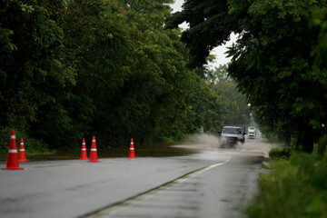 Cars drive on a flooded road after a storm in Thailand.