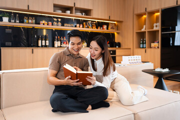 Young couple man and woman asian husband and wife in a relationship reading book hold books on the...
