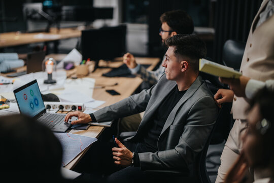 A group of diverse colleagues collaborates on a project, analyzing data and discussing strategies to meet deadlines in a modern office setting. - Powered by Adobe