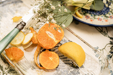 Halved orange and lemon slices with green-handled vintage knife on glass tray