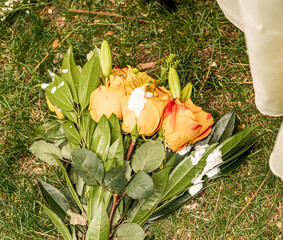 Bouquet of orange roses and green leaves with whipped cream on grass