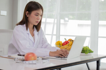 A female scientist in a lab coat is analyzing data on a laptop in a lab, researching medicine, DNA, chemistry, and healthcare with determination and confidence.