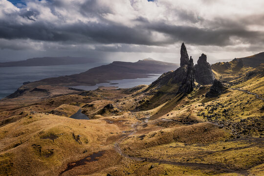 Aerial view of the rugged, towering Old Man of Storr piercing through the dramatic Scottish Highlands under a moody sky, Isle of Skye, Scotland, United Kingdom.