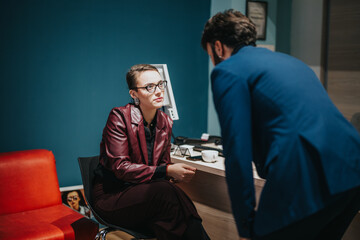 Two colleagues in a modern office setting having a discussion over work-related matters.