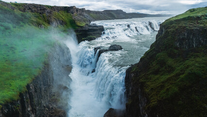 Majestic Gullfoss waterfall cascades down rocky cliffs in Icelands stunning landscape
