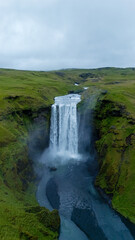 Fototapeta premium Majestic Skogafoss waterfall cascading through lush Icelandic countryside