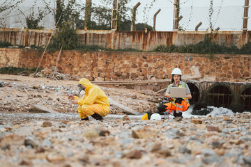 Environment scientist with team analysing waste water test results and collecting sample for...