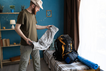 bearded man packing backpack for camping trip