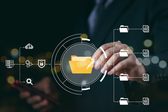 Document Management System (DMS) being setup by IT consultant working on laptop computer in office. Software for archiving, searching and managing corporate files and information