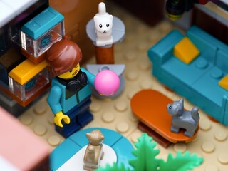 Obraz premium Tambov, Russian Federation - July 05, 2025 Lego girl minifigure playing with three Lego kittens in her apartment