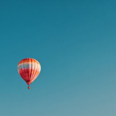 Obraz premium Vibrant Hot Air Balloon Against Clear Blue Sky Background