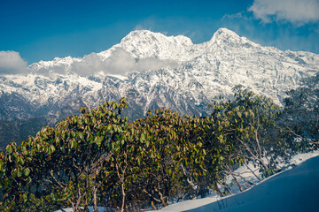 The front view of the Annapurna South peak is covered by snow on top in winter, Mardi Himal trek, Nepal. Clear sky on a sunny day. The idea for a soft-toned nature background with copy space.