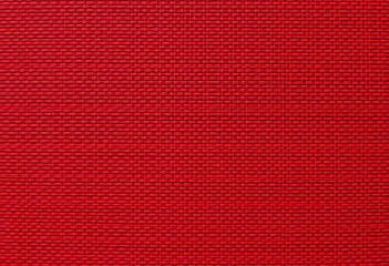 Intricate red textile pattern with textured weave, ideal for background, retro, design element