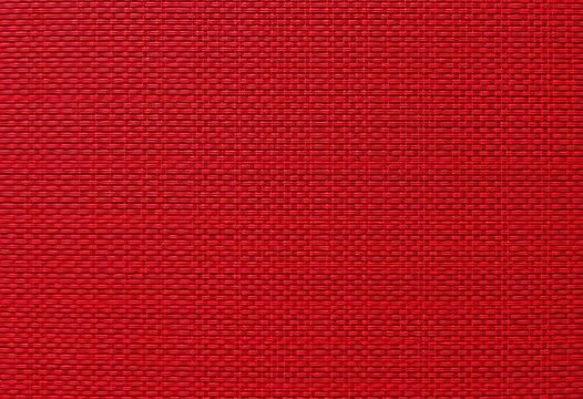Intricate red textile pattern with textured weave, ideal for background, retro, design element