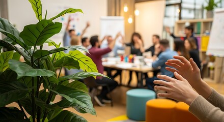 A diverse team in a modern office enthusiastically participates in a meeting with hands raised in engagement