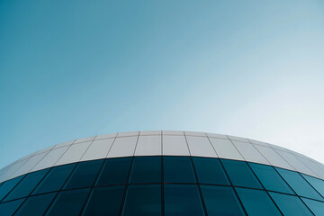 Modern architectural dome with blue glass facade against a clear sky
