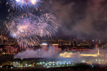 View of bursts of colorful fireworks illuminate the night sky over a cityscape with buildings and lights, a magical spectacle, Moscow, Moscow, Russia.